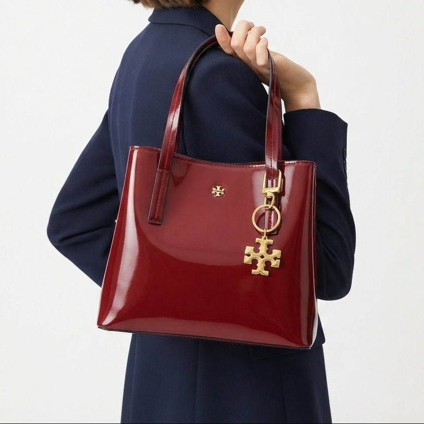 Tory Burch Patent Leather Handbag with Gold Tone Logo Charm